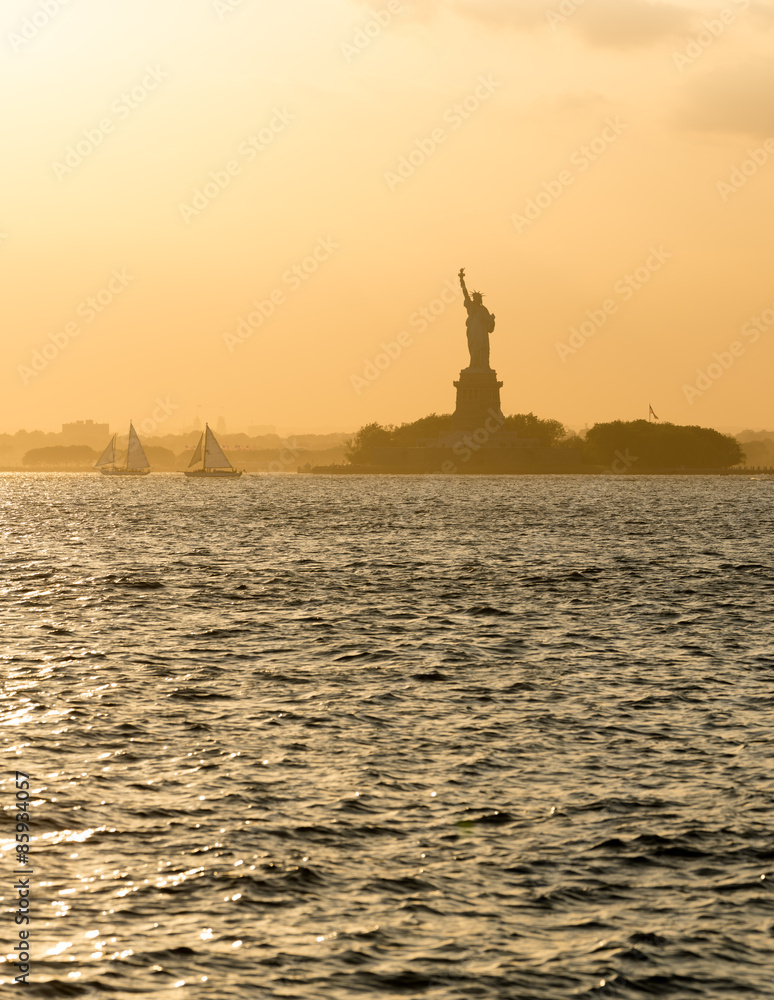 Statue of Liberty before sunset in hazy New York Harbor