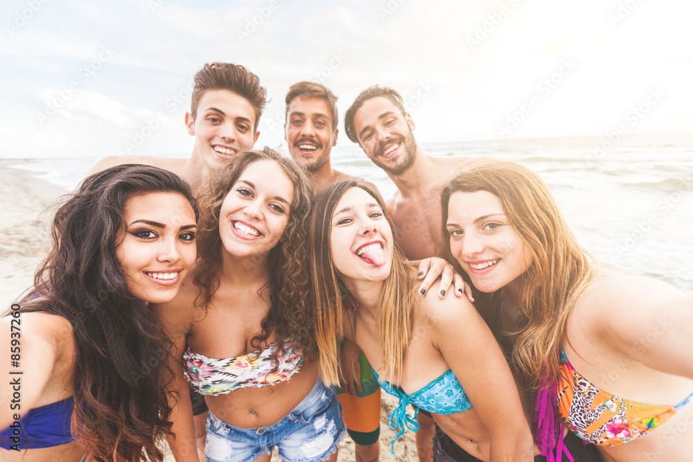 Multiracial group of friends taking selfie on the beach