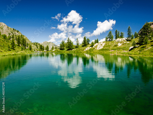 glacial lake with clear blue water and clouds reflections