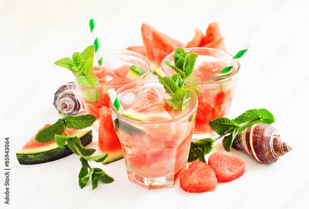 Refreshing summer watermelon drink with mint and ice cubes, sea shells, selective focus Refreshing summer watermelon drink with mint and ice cubes, sea shells, selective focus