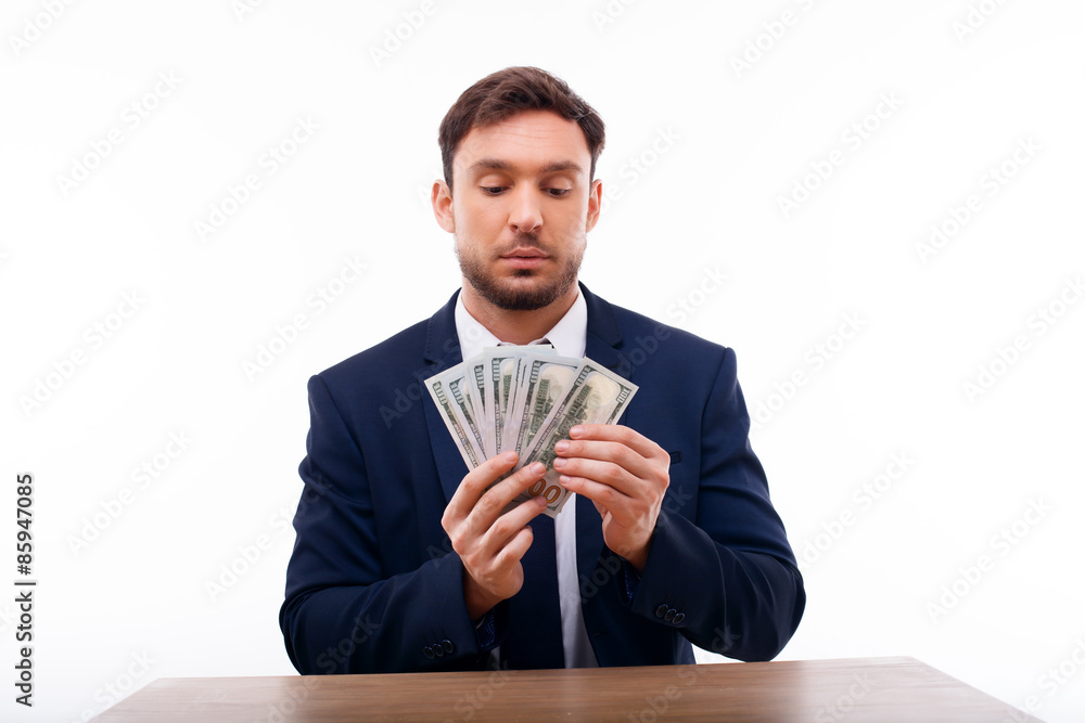 Handsome young man is calculating his savings Handsome young man is calculating his savings
