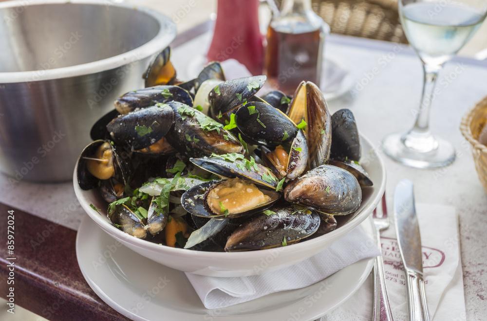 A bowl of delicious moules mariniere (mussels) ready for lunch in a seafood restaurant in Brighton, East Sussex, UK