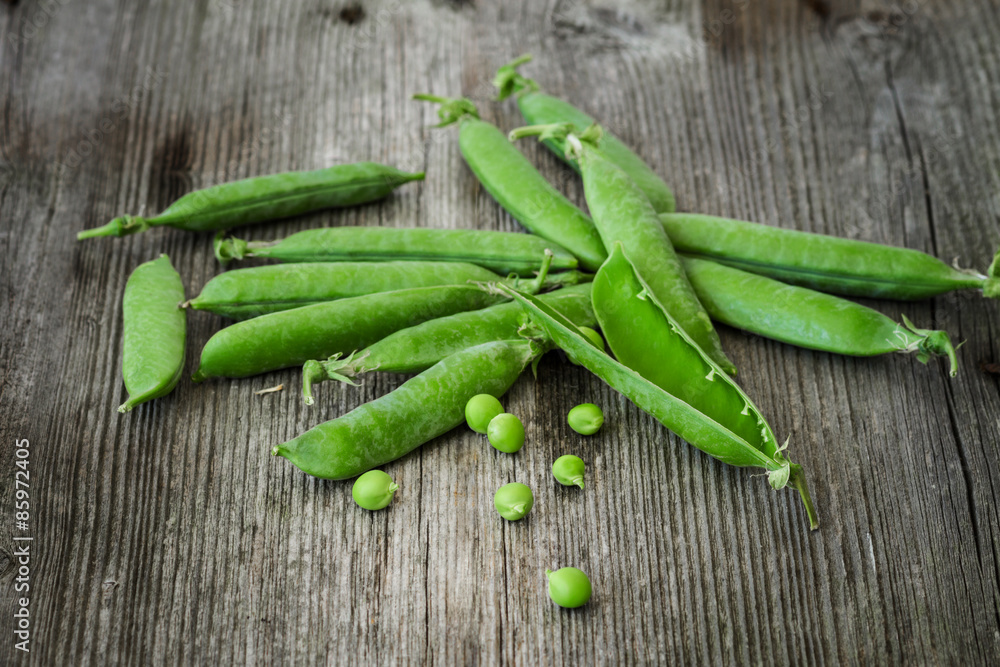 fresh green peas over a rustic wood table fresh green peas over a rustic wood table