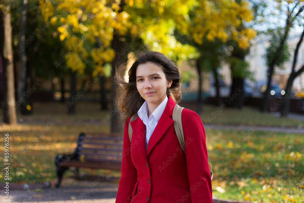 Young pretty woman standing in the autumn park