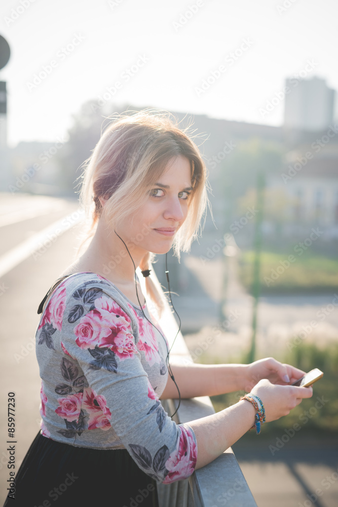 Fototapeta premium young beautiful blonde woman outdoor listening music