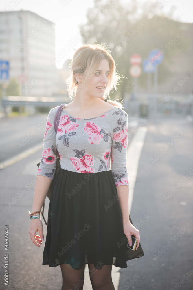 Young woman standing on street during sunset Young woman standing on street during sunset