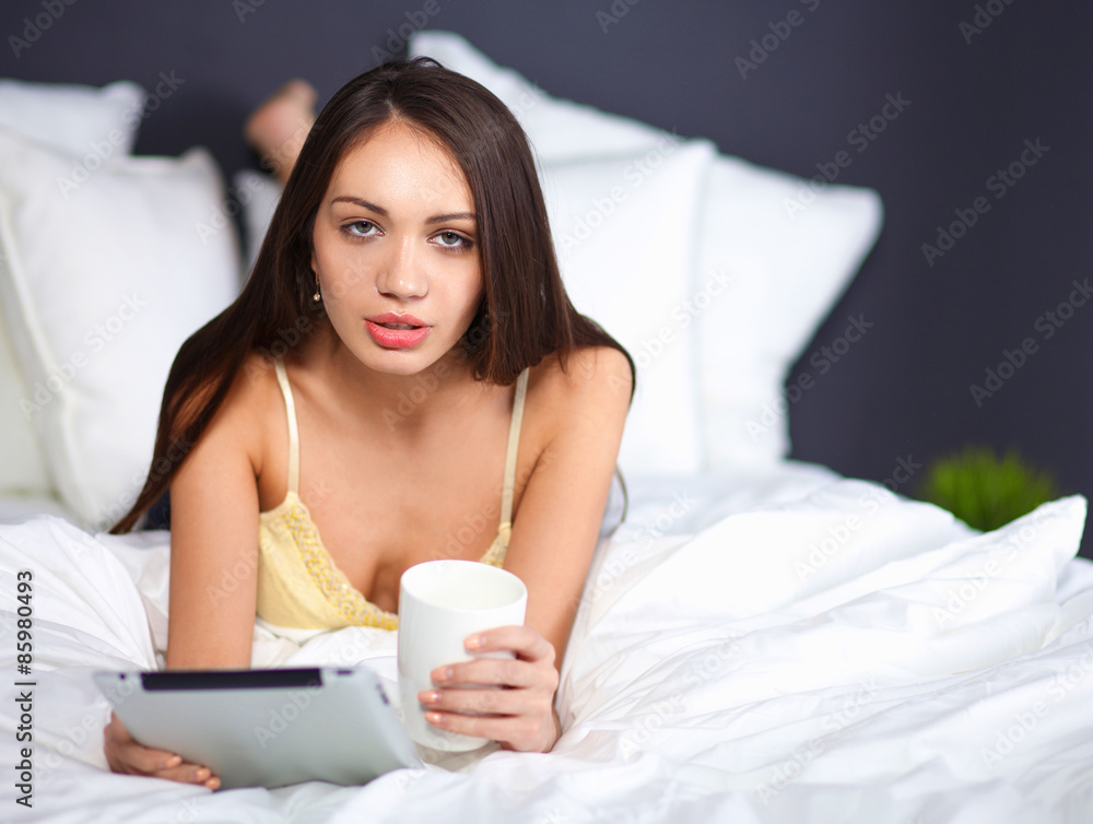Women use a tablet pc on the bed Women use a tablet pc on the bed