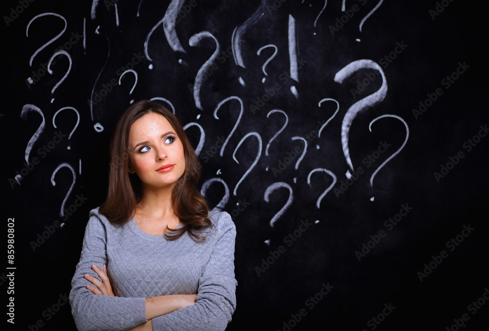 Young girl with question mark on a gray background Young girl with question mark on a gray background