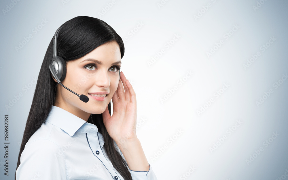 Portrait of smiling cheerful support phone operator in headset. Studio blue background. Portrait of smiling cheerful support phone operator in headset. Studio blue background.