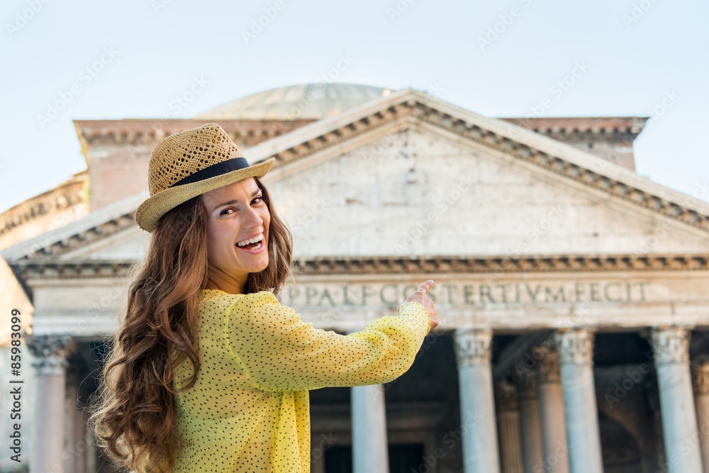 Smiling woman tourist pointing at Pantheon in Rome in summer