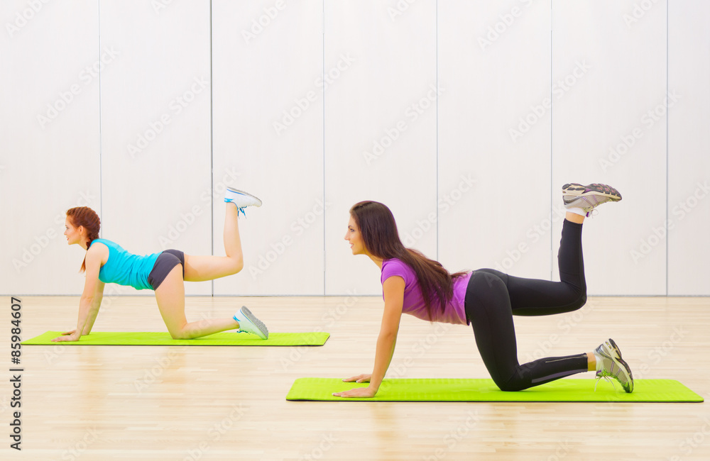 Fototapeta premium Two sporty girls at fitness club