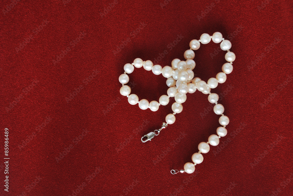 pearl necklace on red velvet background pearl necklace on red velvet background
