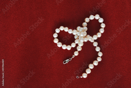 pearl necklace on red velvet background