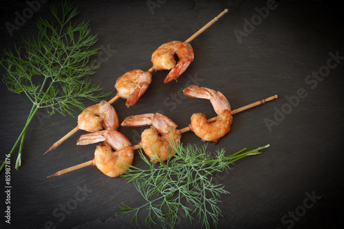 Grilled shrimp with dill on a black stone