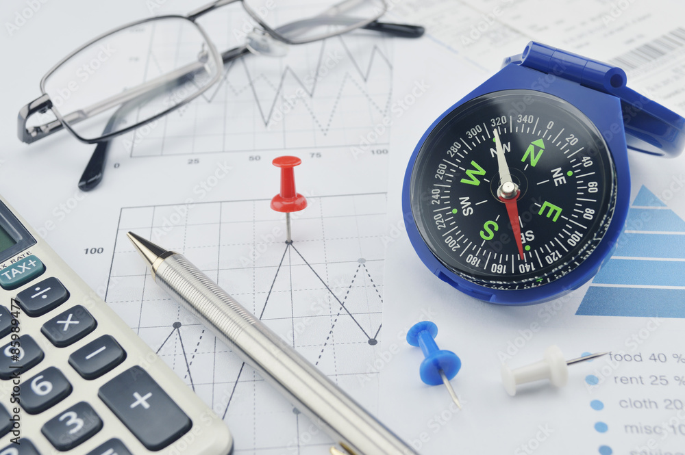 Blue compass, pen and pin on graph paper, success concept Blue compass, pen and pin on graph paper, success concept