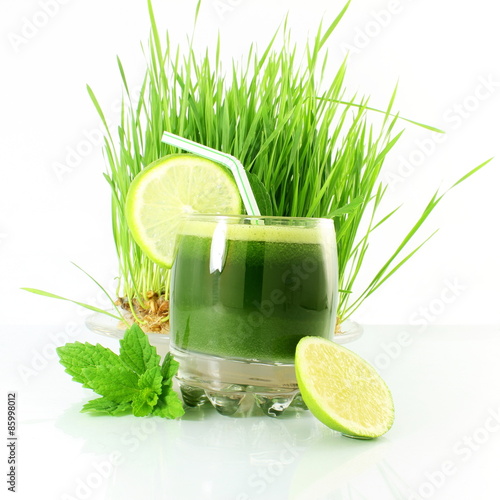 fresh sprouted wheat grass juice with wheat grass in white background