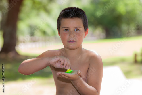 niño jugando a la peonza en el parque
