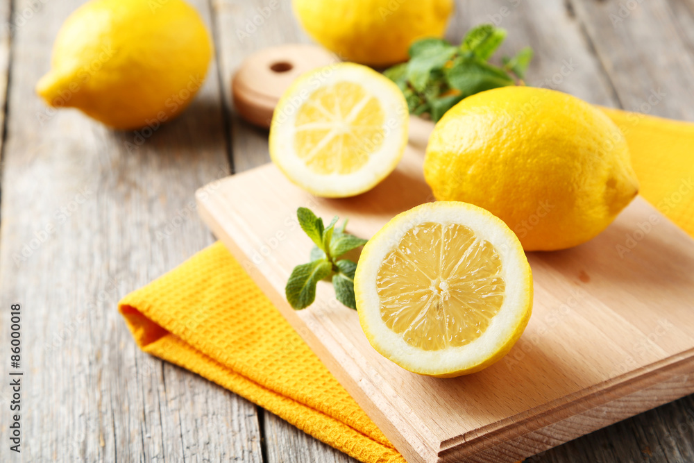 Lemons on cutting board on grey wooden background Lemons on cutting board on grey wooden background
