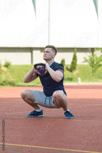Young Man Working Out With A Kettle Bell