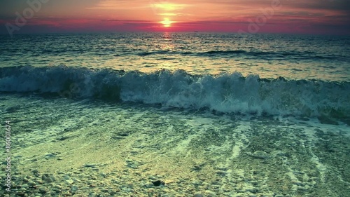 Slow motion. Sea waves near the shore on sunset or sunrise. Beautiful golden hour sea surf landscape. Calm and relax background.