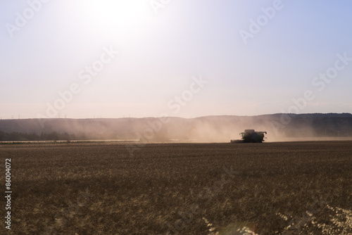 combine harvester agriculture machine harvesting golden ripe wheat field at sunset © W PRODUCTION