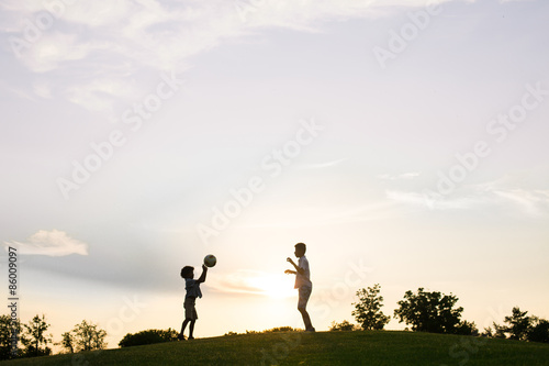 Two boys are playing on sunset.