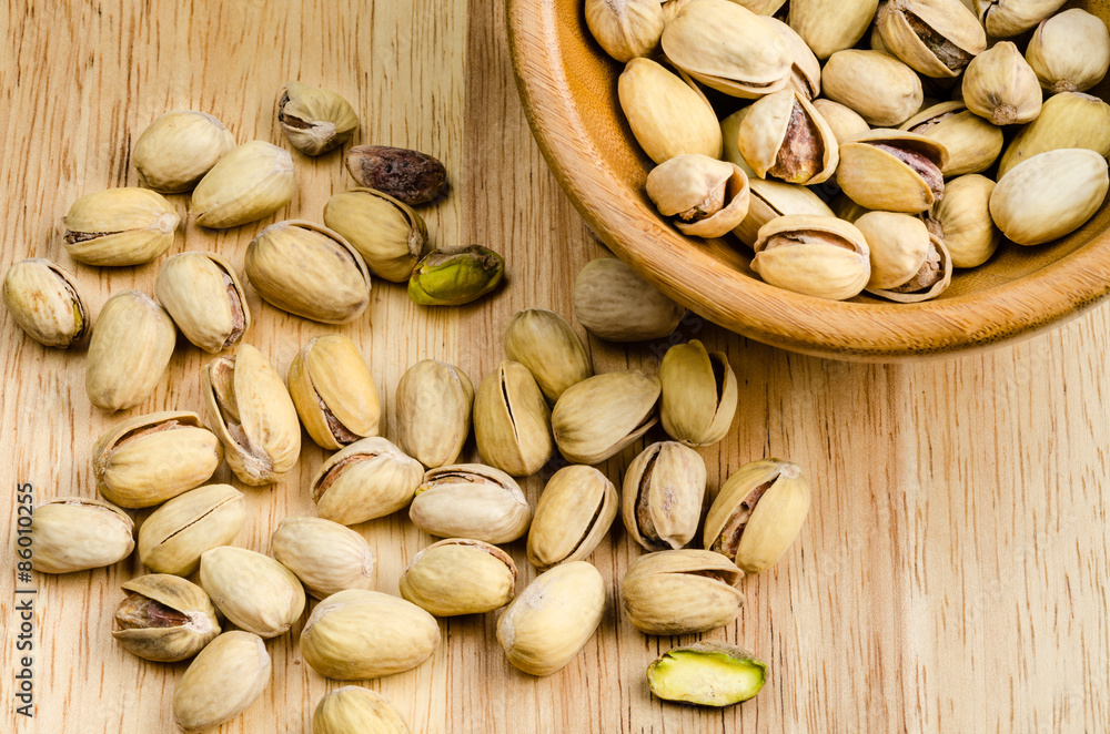 roasted and salted pistachios on wooden background roasted and salted pistachios on wooden background