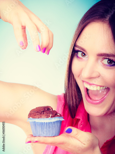 Smiling woman holds chocolate cake in hand