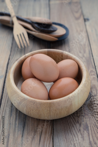 The eggs in the wooden bowl with spoon and fork