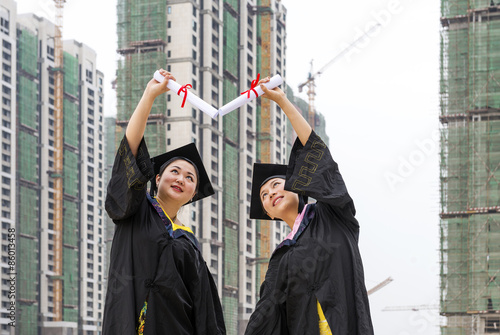 Beautiful female graduates wearing a graduation gown