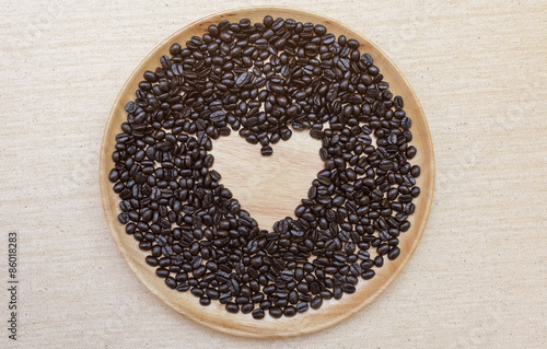 Heart shape coffee beans on wooden plate © sirirak