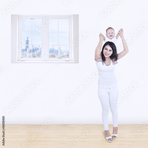 Smiling mom play with baby at home