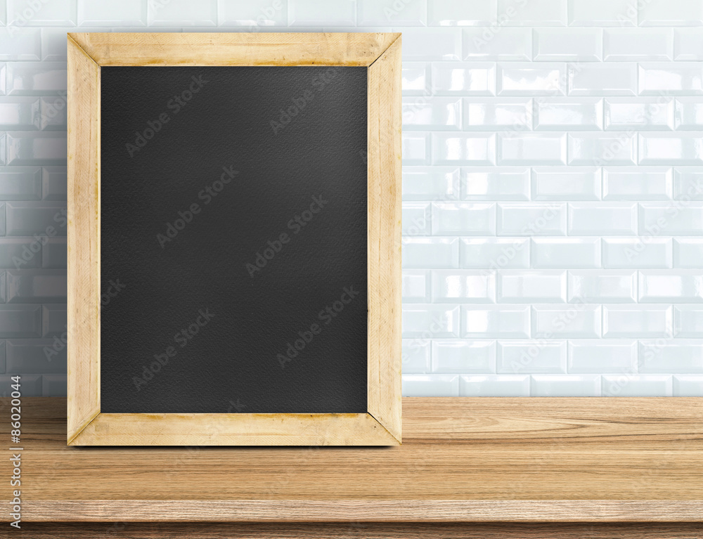Blank blackboard on tropical wooden table at white tile wall,Tem