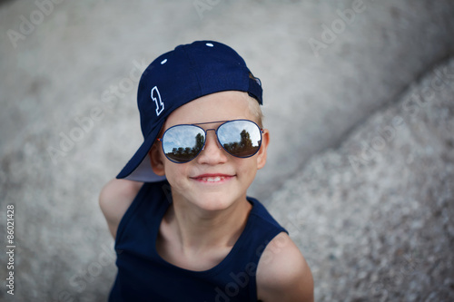 Portrait of Fashionable little boy in sunglasses and cap. Childh photo