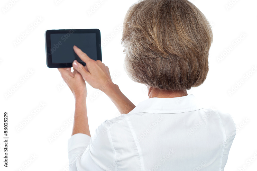 Mature woman using tablet, from back.