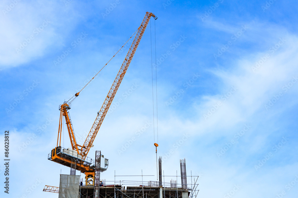 Building crane and construction site under blue sky