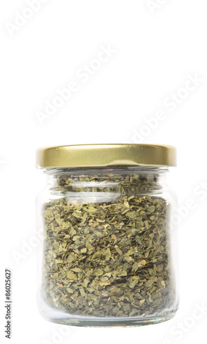 Dried parsley herb in a mason jar over white background