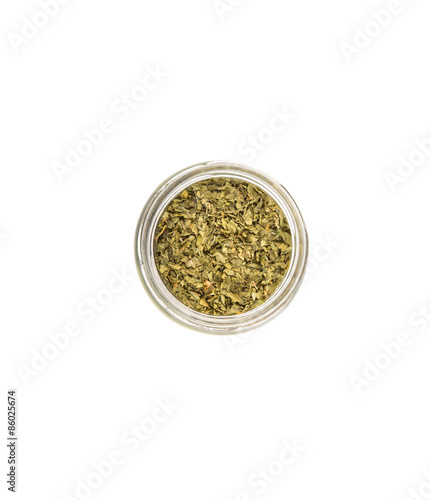 Dried parsley herb in a mason jar over white background