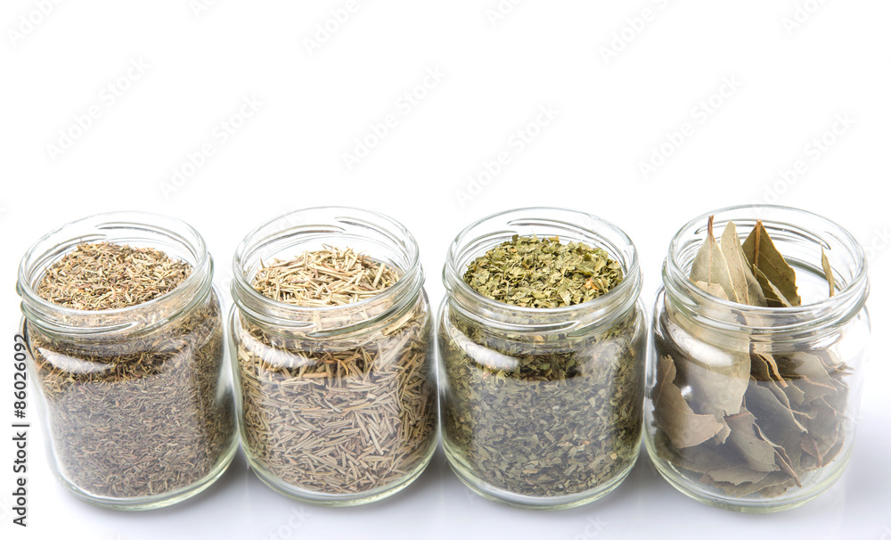 Herbs variety of rosemary, parsley, bay leaves and thyme in mason jars Herbs variety of rosemary, parsley, bay leaves and thyme in mason jars