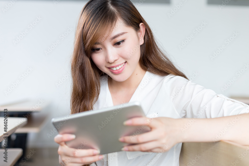 Asian beautiful female student study with tablet in classroom Asian beautiful female student study with tablet in classroom