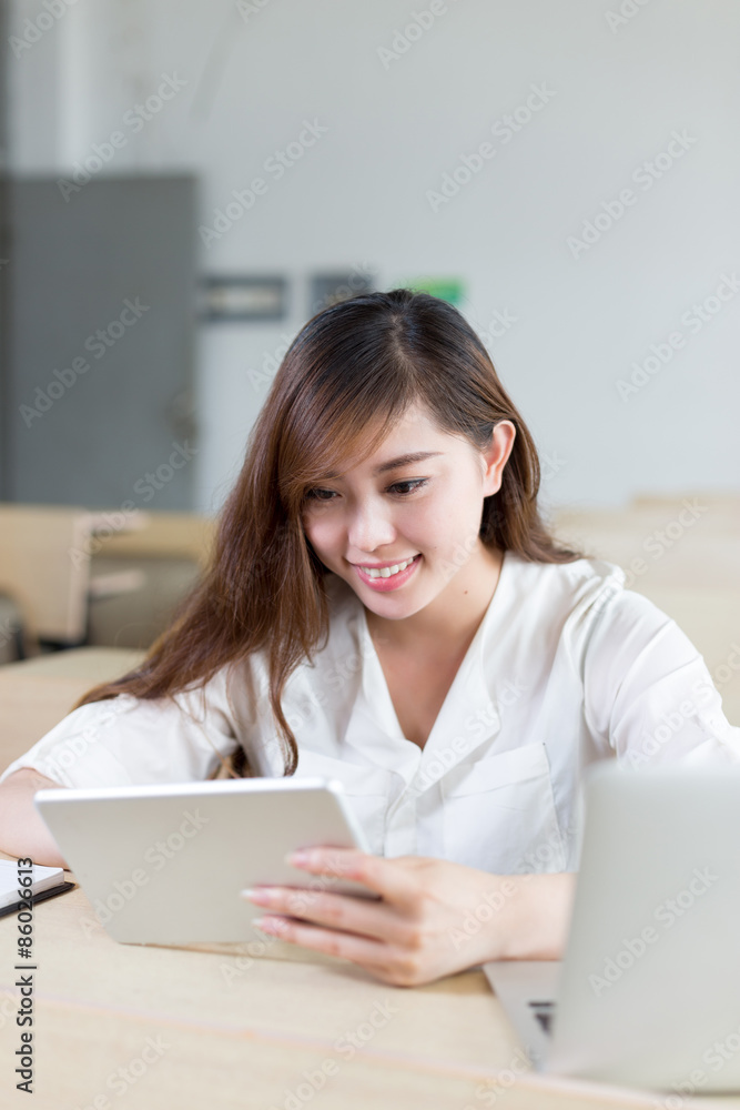 Asian beautiful female student study with tablet in classroom Asian beautiful female student study with tablet in classroom