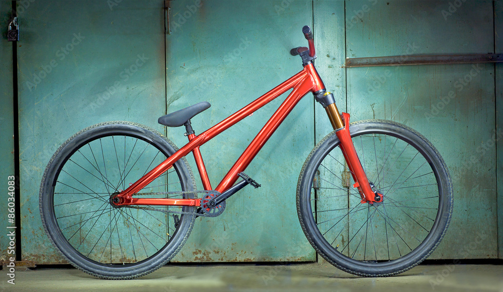 Red bicycle on a green garage background Red bicycle on a green garage background