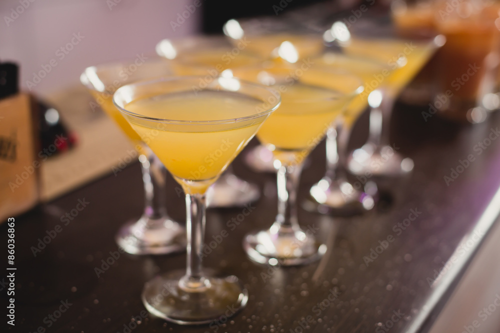 Beautiful line of different colored alcohol mojito cocktails with mint on a open air party, tequila, martini, vodka, and others on decorated catering bouquet table on open air event party. Beautiful line of different colored alcohol mojito cocktails with mint on a open air party, tequila, martini, vodka, and others on decorated catering bouquet table on open air event party.