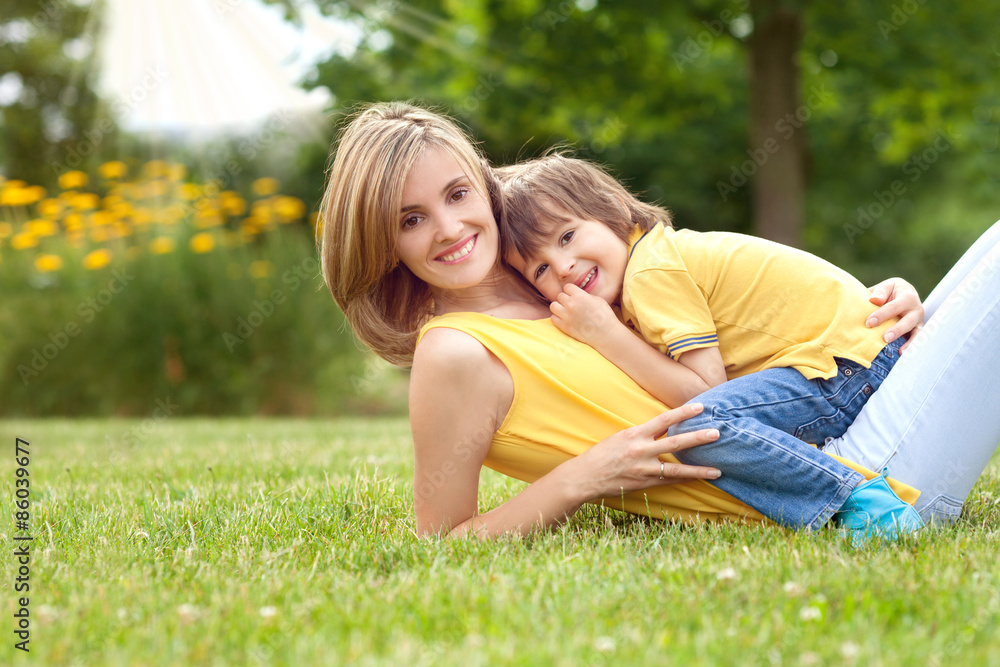 Young beautiful mom and her cute little boy, relaxing and having Young beautiful mom and her cute little boy, relaxing and having