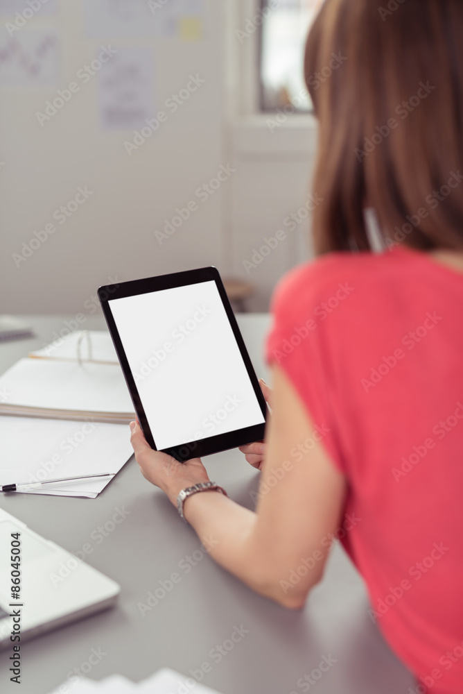 frau sitzt am schreibtisch und liest am tablet-pc frau sitzt am schreibtisch und liest am tablet-pc