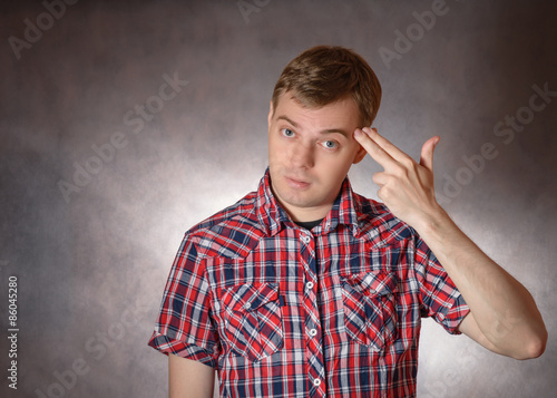 Fotografia Young man shows headshot with his fingers