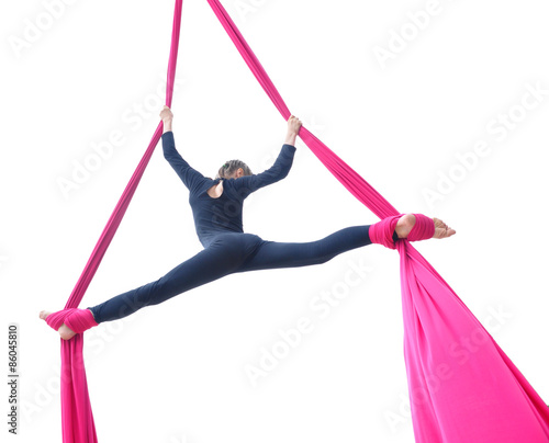 cheerful child training on aerial silks, isolated over white