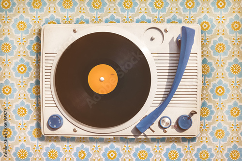 Vintage record player on top of flower wallpaper