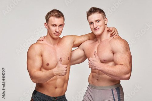 Two athletic men gesturing thumbs up