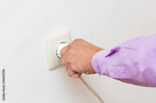 Close Up Of Hand Putting Plug Into Electricity Socket.